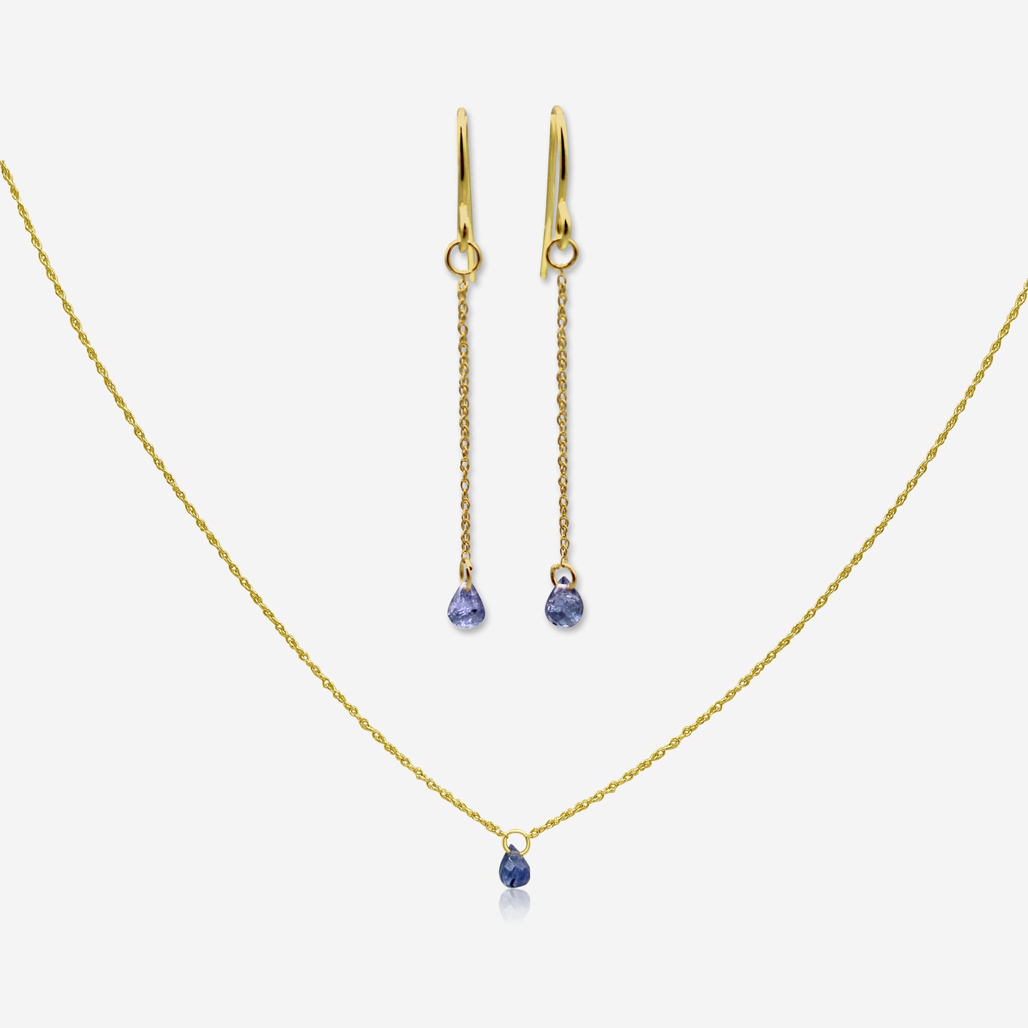 Gold necklace and earrings with blue gemstones on a white background