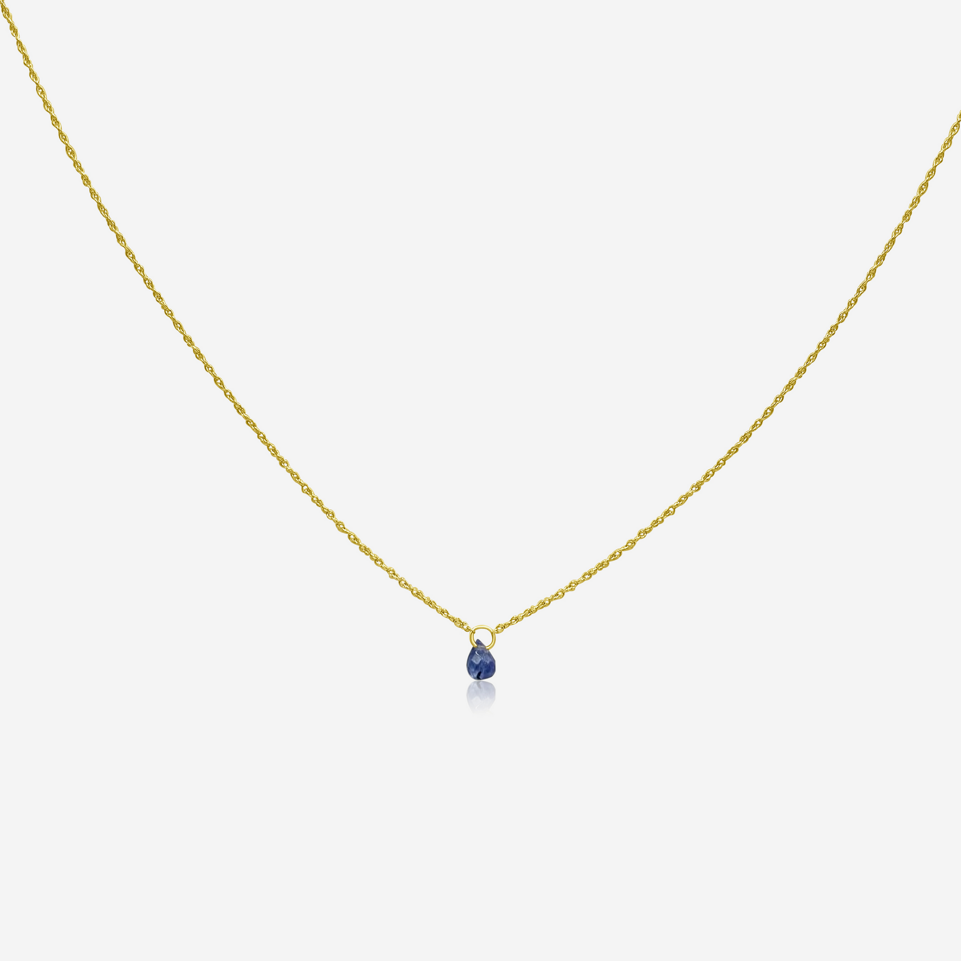 A single Tanzanite drop necklace on a gold chain against a white background.