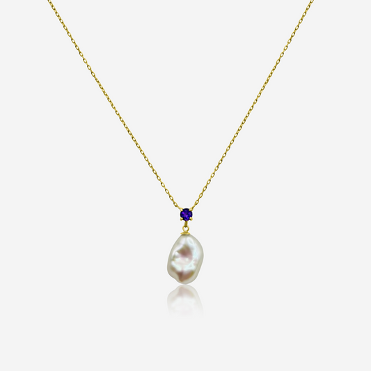 A gold-tone necklace featuring a drop-shaped freshwater pearl pendant with smaller amethyst beads above it on a white background.