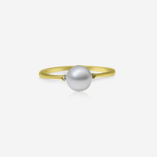 A gold ring with a central pearl and two side diamonds