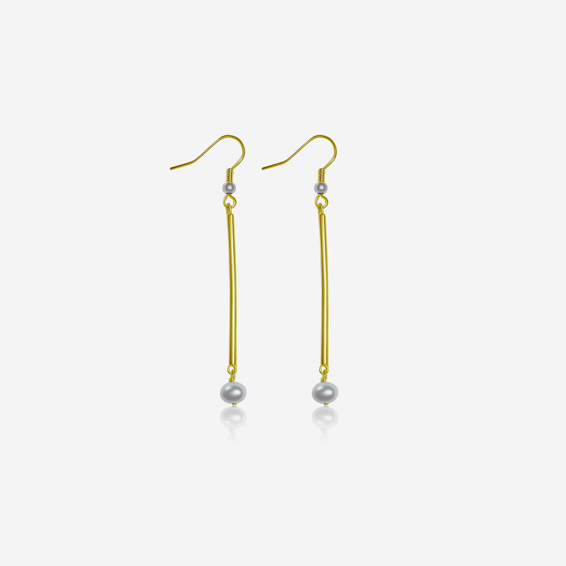 A pair of tube earrings with gold posts and freshwater pearls dangling.