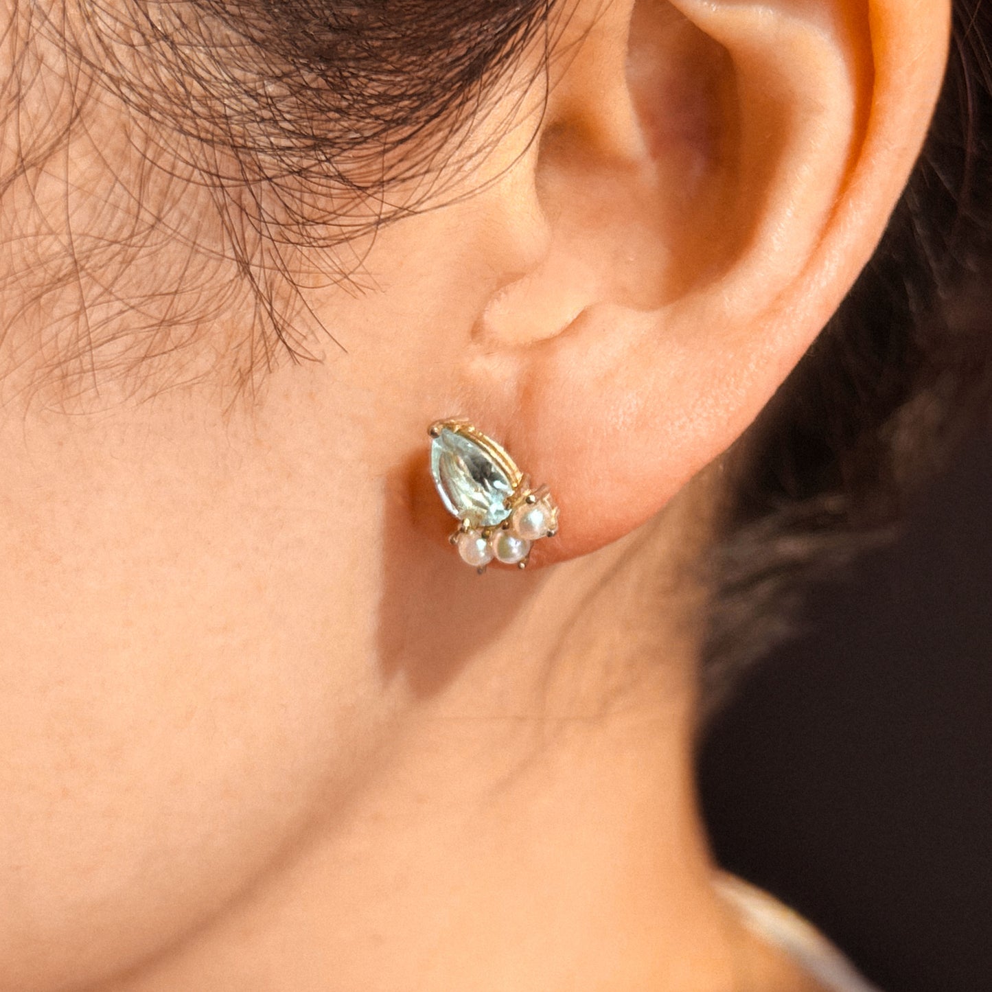A pair of gold earrings featuring pear-shaped aquamarine stones and small round Akoya pearls arranged in a cluster.