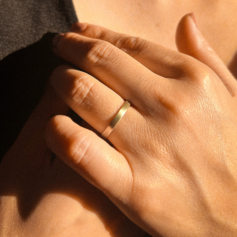 A simple gold wedding band with a matte finish.