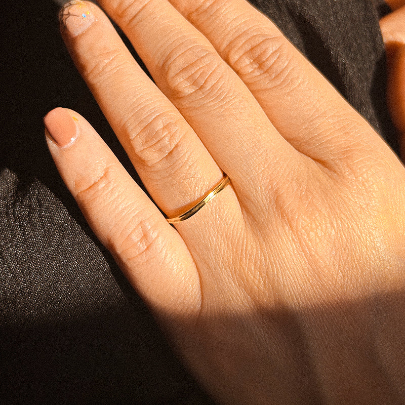 A simple, delicate ring with an organic, natural shape, crafted in a shiny gold material.