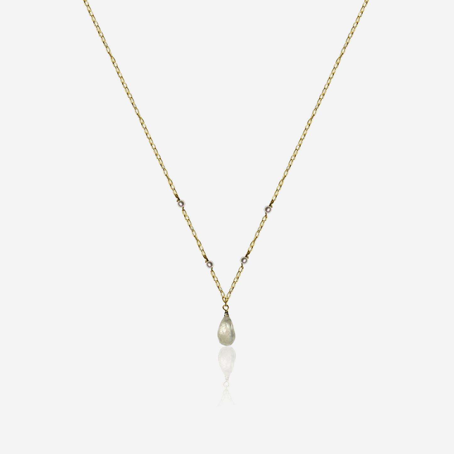 A gold-colored necklace featuring a series of Akoya pearls accompanied by a large Moonstone pendant.
