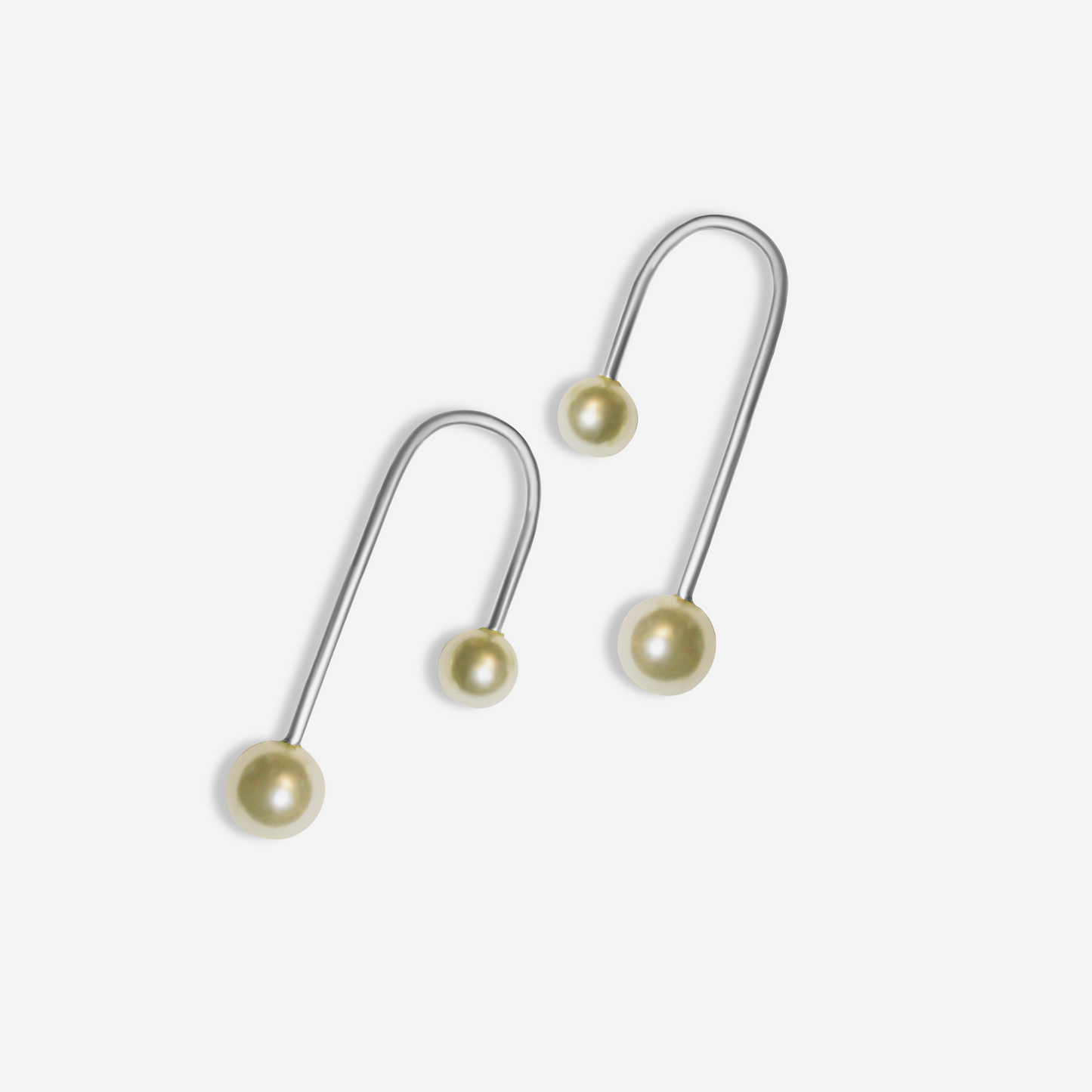 A pair of Freshwater pearl earrings in gold, displayed alongside a tube.