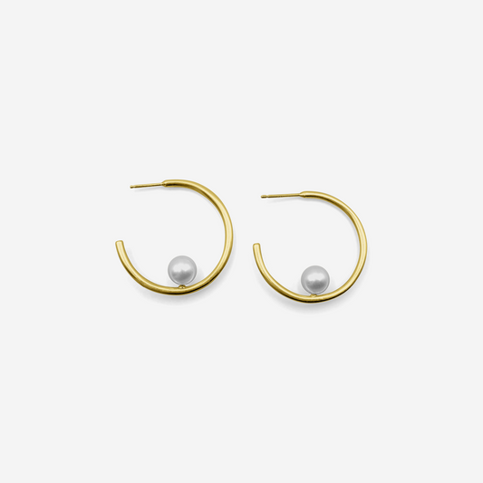 Gold hoop earrings with pearls on a white background