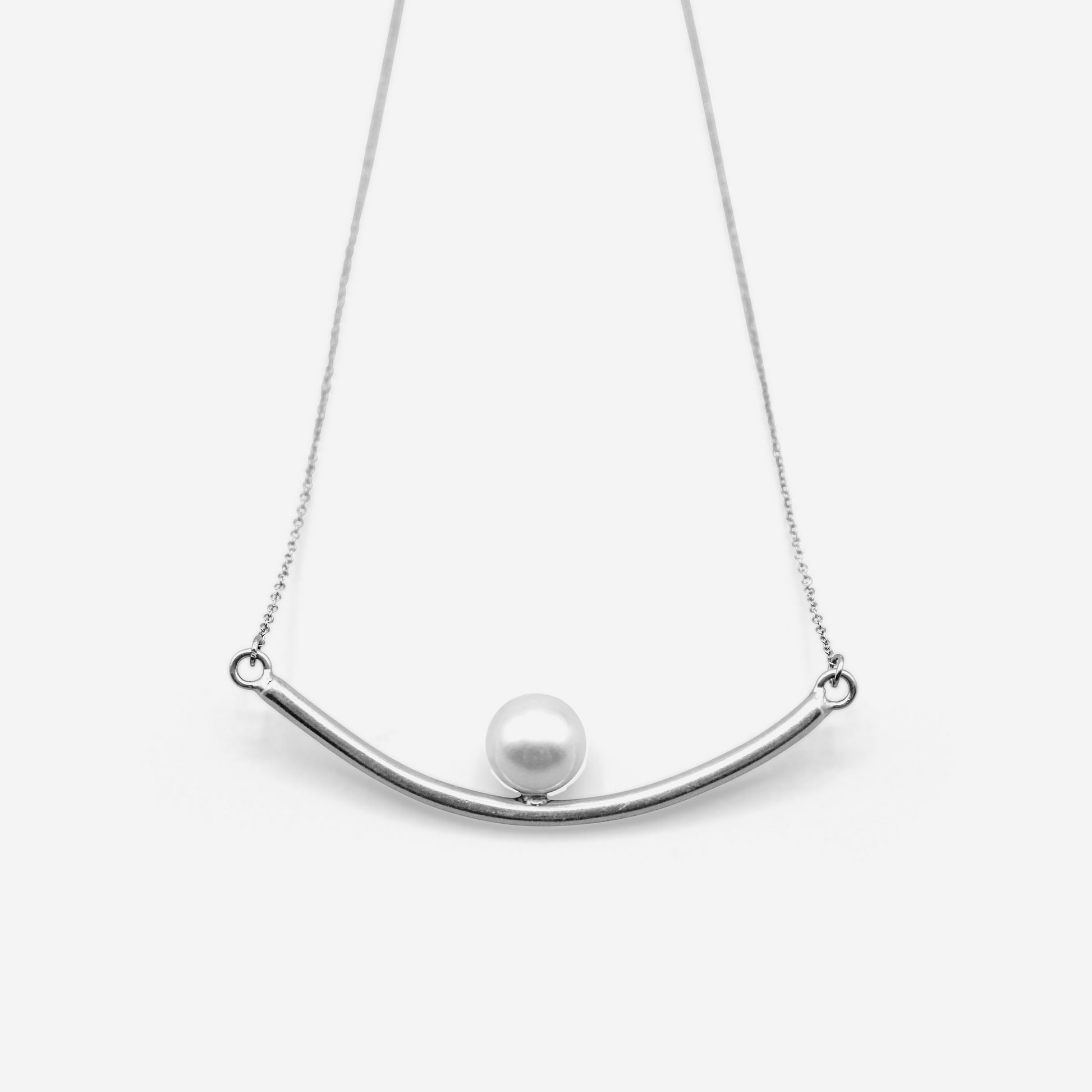 A tube-shaped pendant necklace with an Akoya pearl elegantly placed in the center, hanging from a delicate chain.