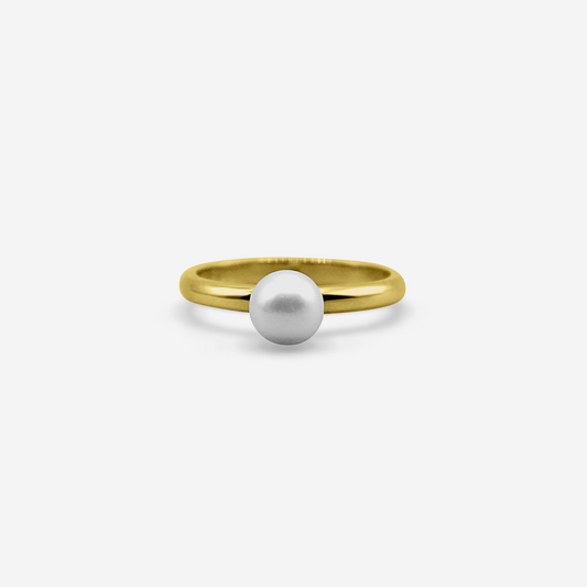 Gold ring with a white pearl on a light gray background