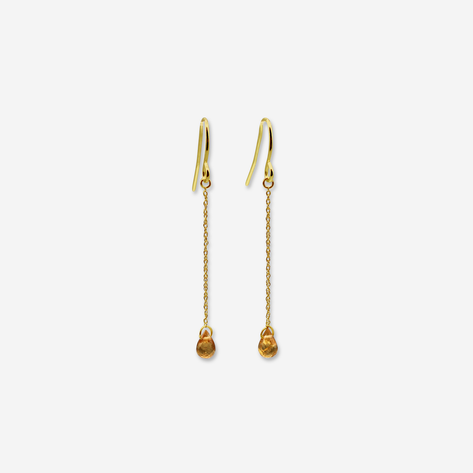A pair of spessartite garnet drop earrings with 14 karat yellow gold hooks and chains, displaying the earrings against a white background.