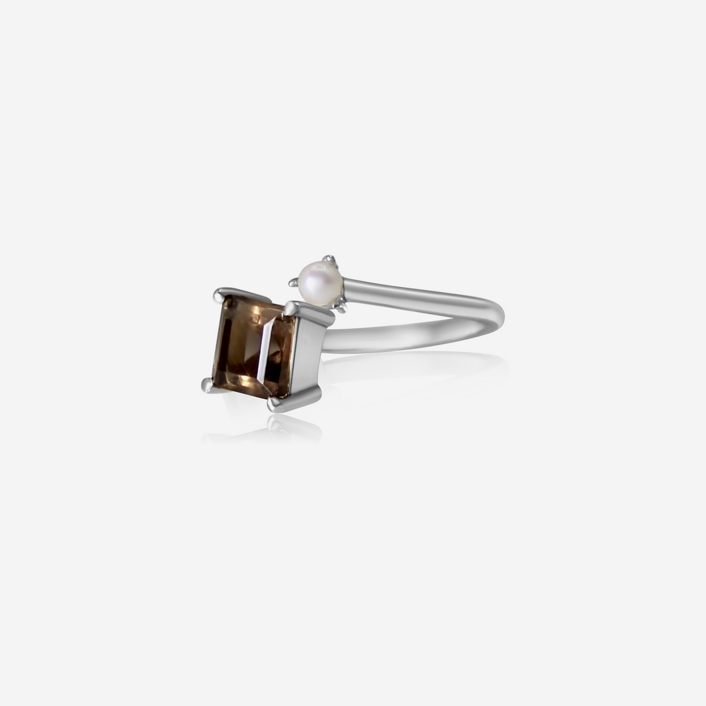 A gold ring featuring a princess cut smoky quartz and a small Akoya pearl on a white background.