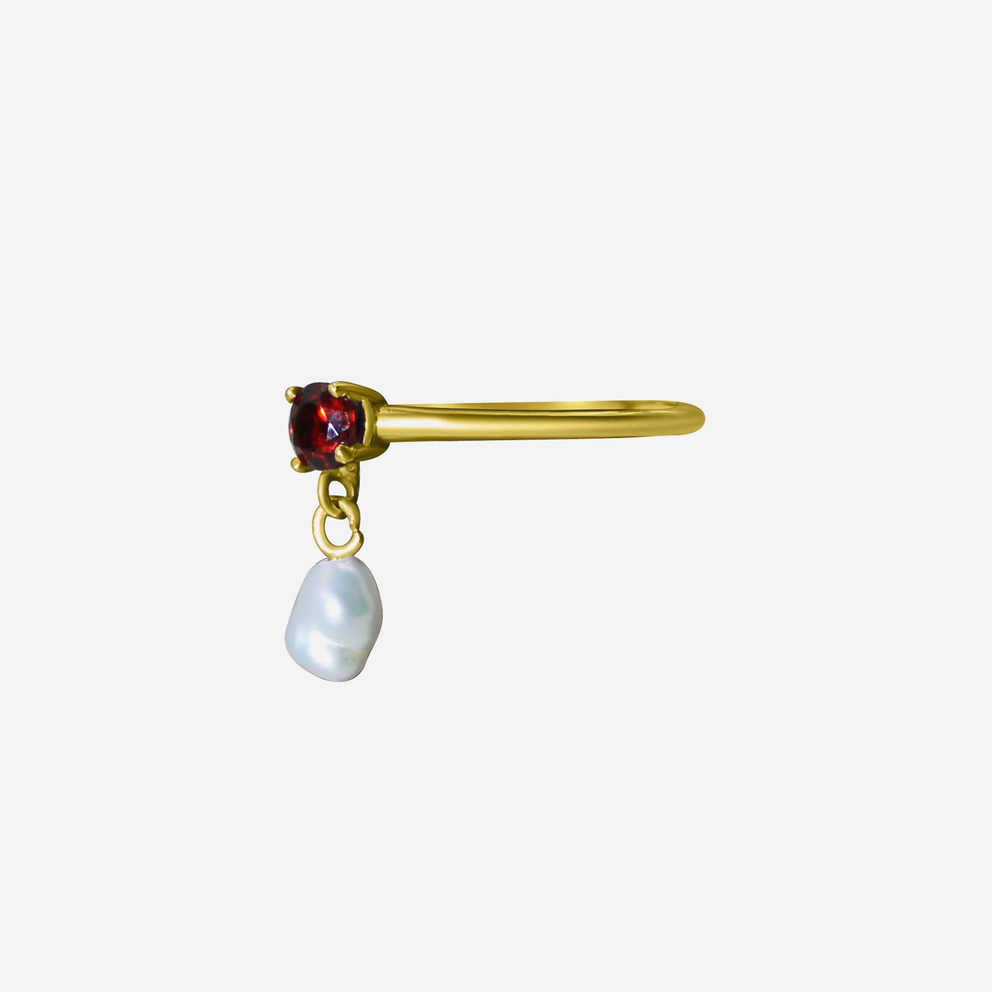 A gold ring with a radiant garnet gemstone and a pearl drop