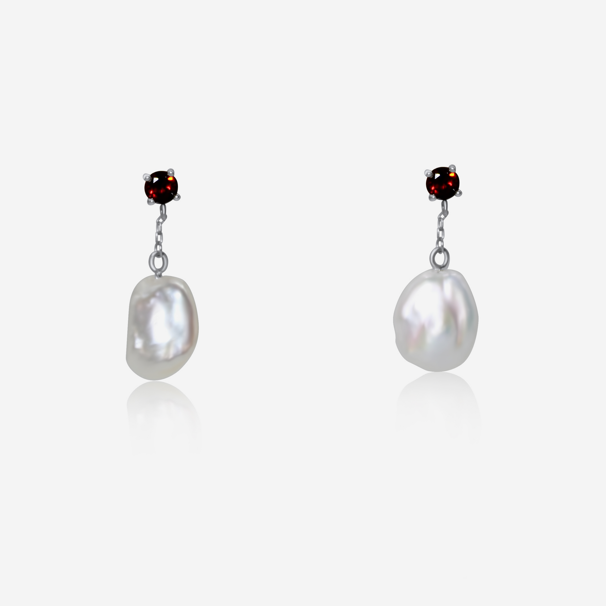A pair of garnet with pearl drop earrings, featuring rich red garnet studs atop gold posts, with lustrous white pearls dangling below.