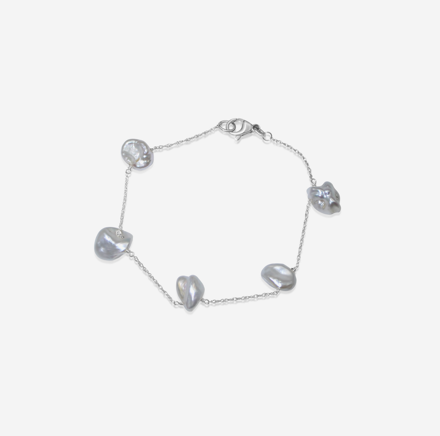 Gold bracelet with heart-shaped pearls on a light gray background
