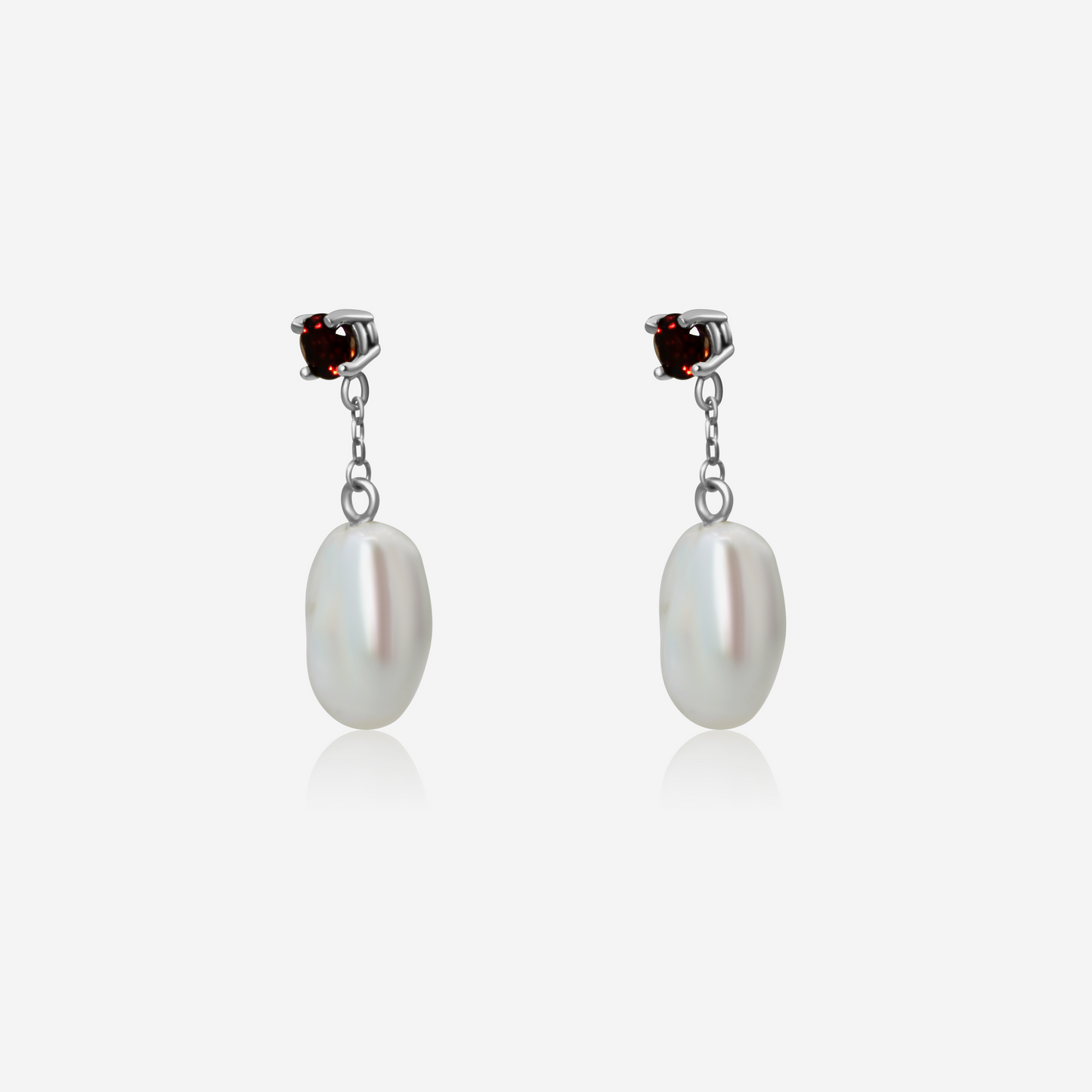 A pair of garnet with pearl drop earrings, featuring rich red garnet studs atop gold posts, with lustrous white pearls dangling below.