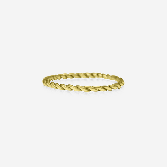 A gold-colored twisted band ring on a white background
