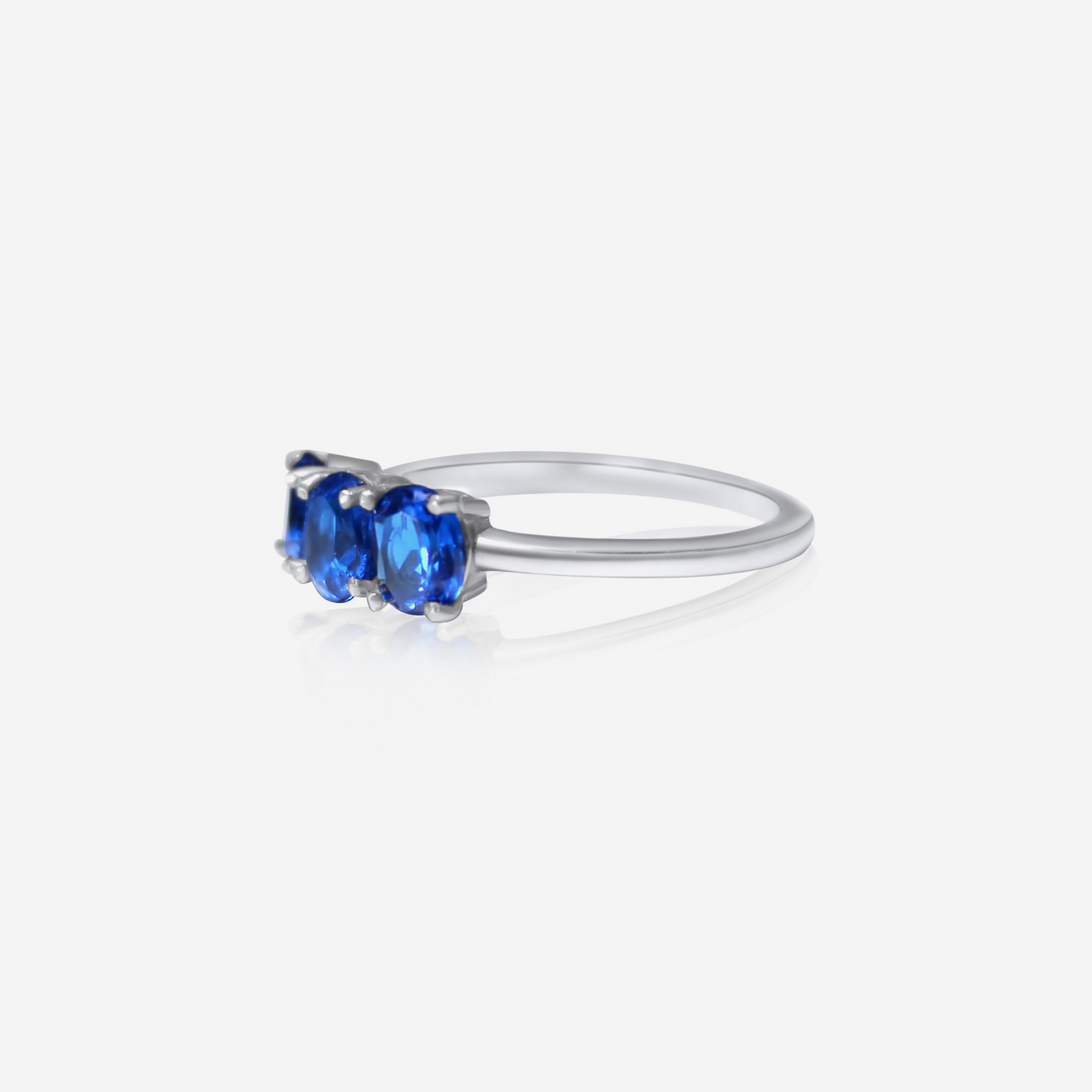 A Trio Sapphire Ring with three blue sapphire stones set in a gold band.