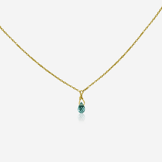 A green apatite drop necklace set in gold, suspended from a gold chain against a white background.