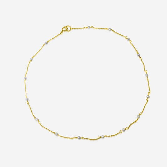A delicate Tiny Akoya Pearl Necklace with small pearls on a gold-tone chain displayed against a white background.