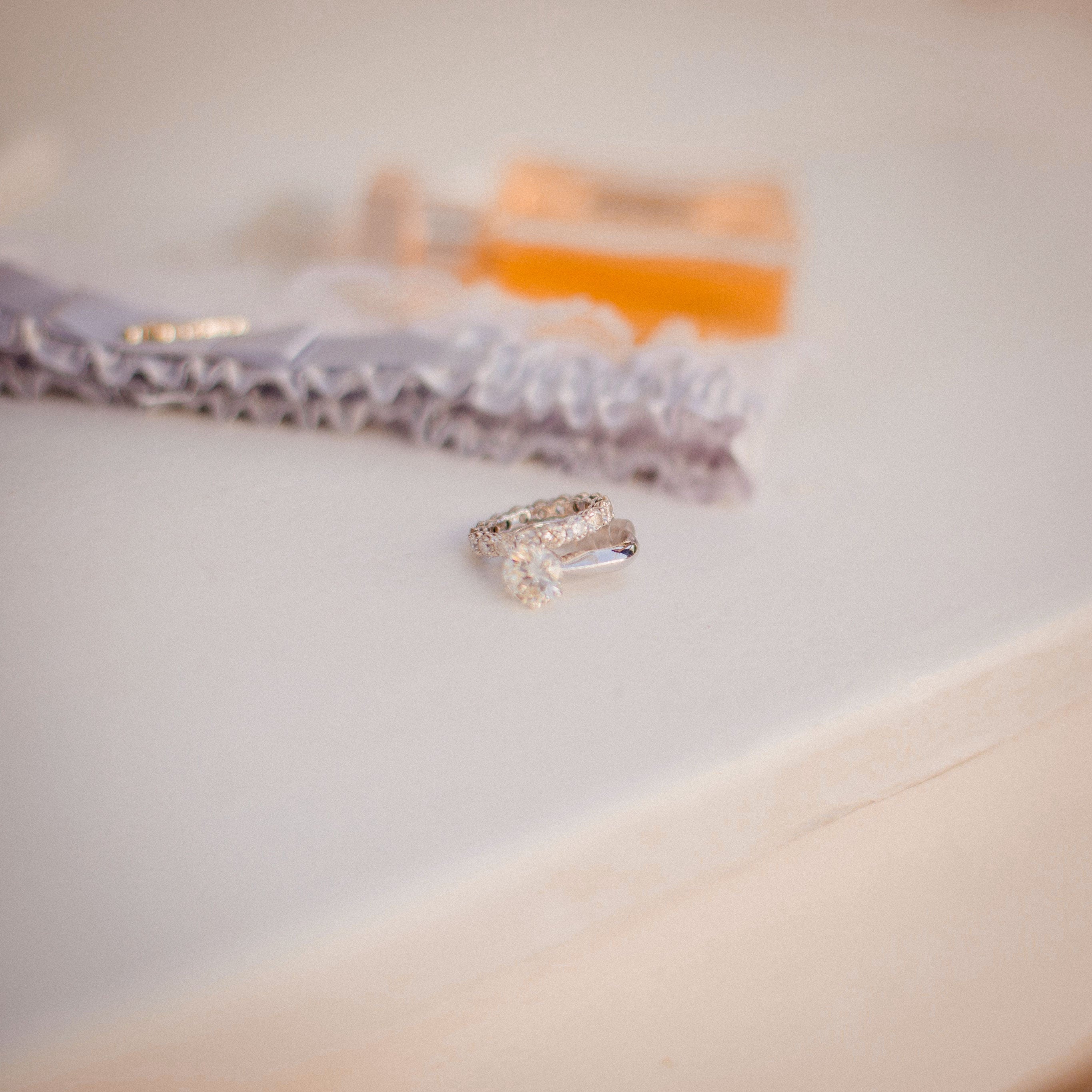 Diamond ring on a white surface with a blurred background
