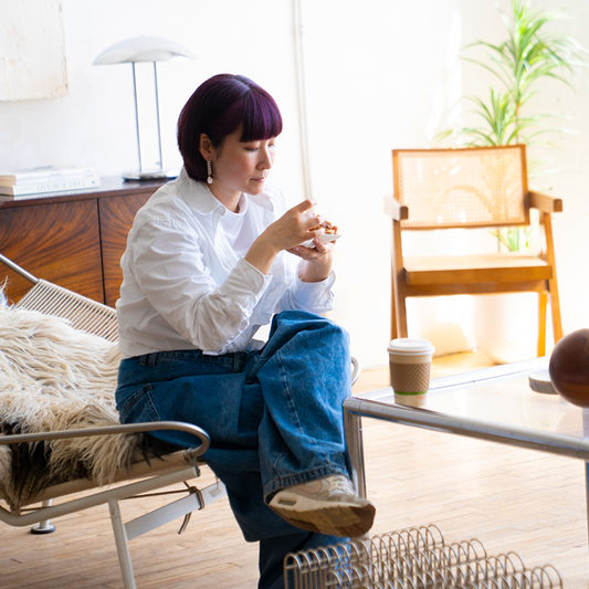 Person sitting on a chair in a modern living room with a coffee cup on the table.