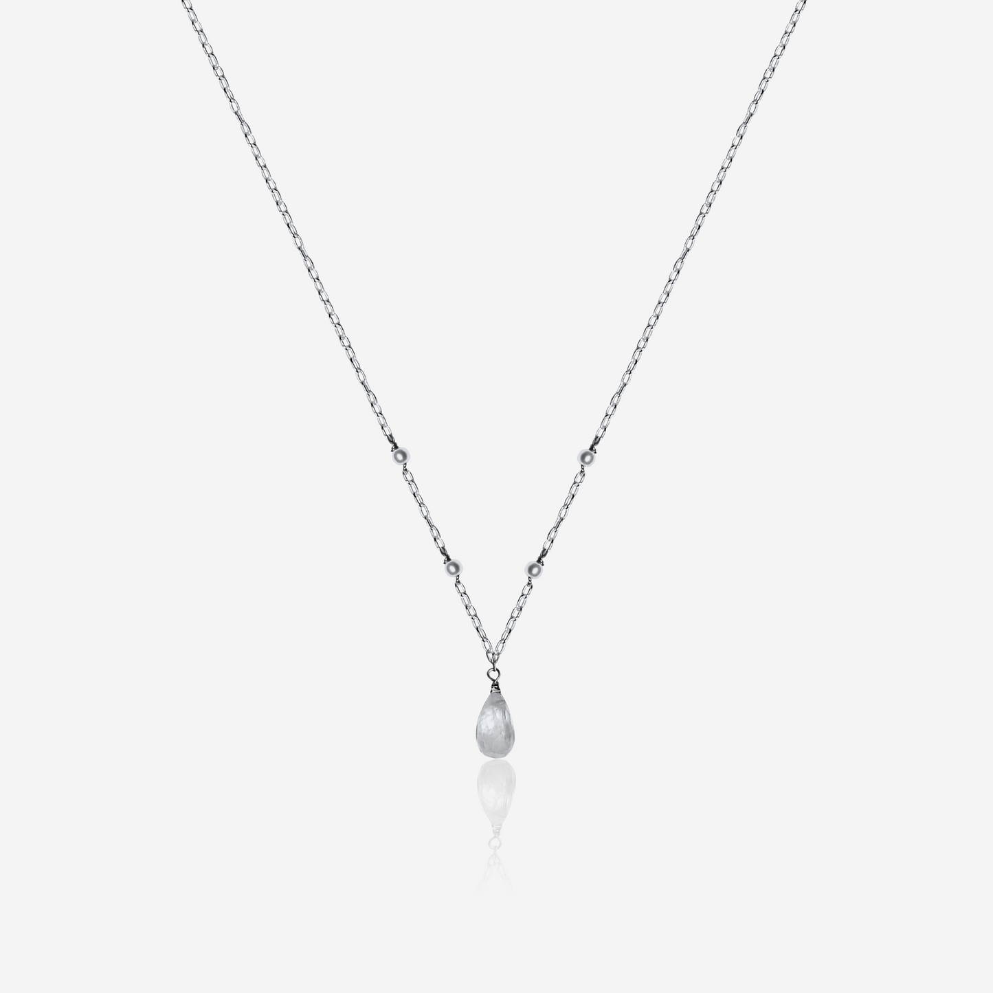 Necklace with a teardrop-shaped pearl pendant on a light gray background