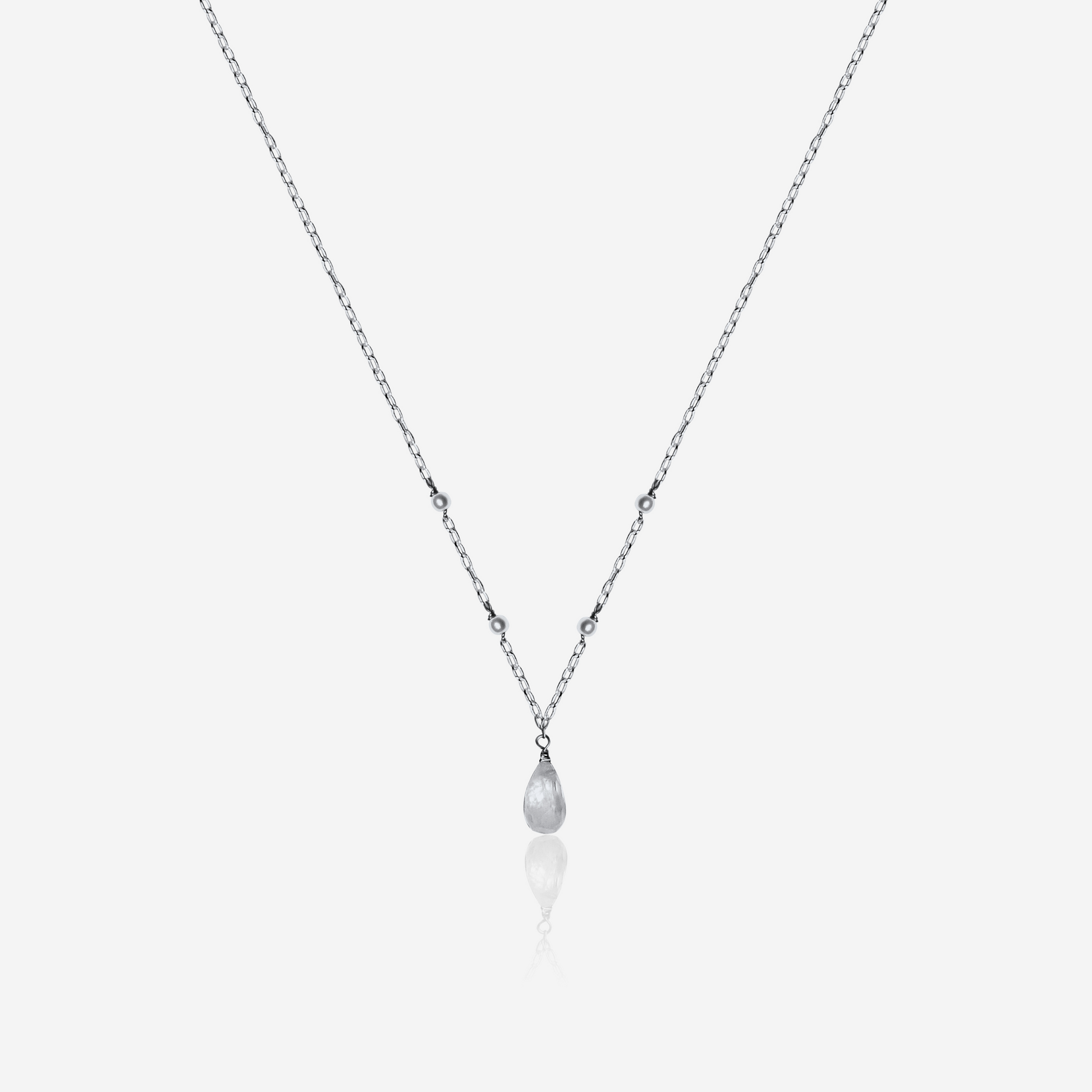 Necklace with a teardrop-shaped pearl pendant on a light gray background