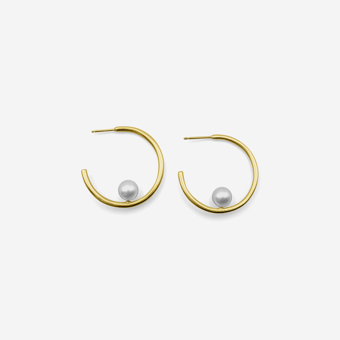 Gold hoop earrings with pearls on a white background