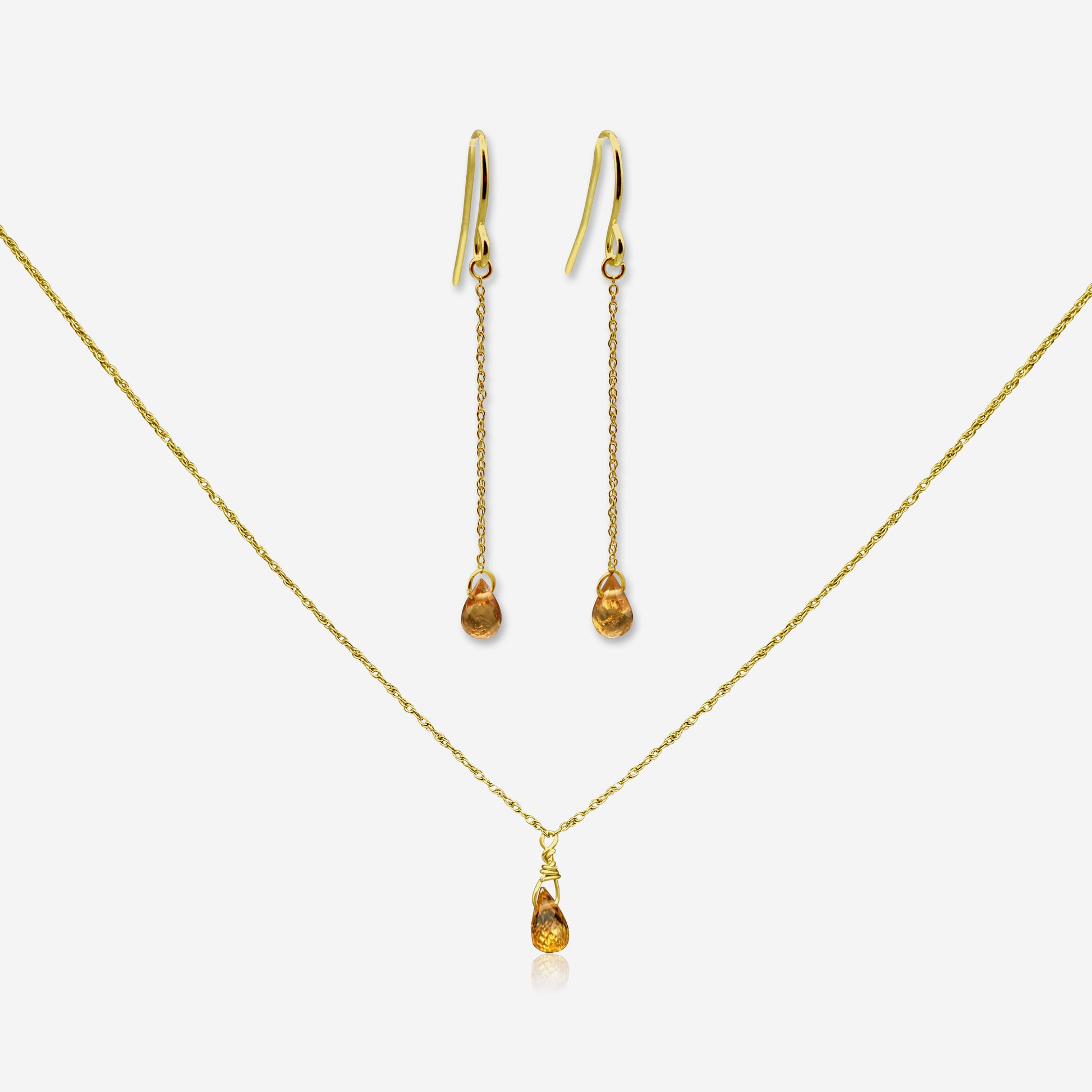 Gold necklace and earrings on a white background